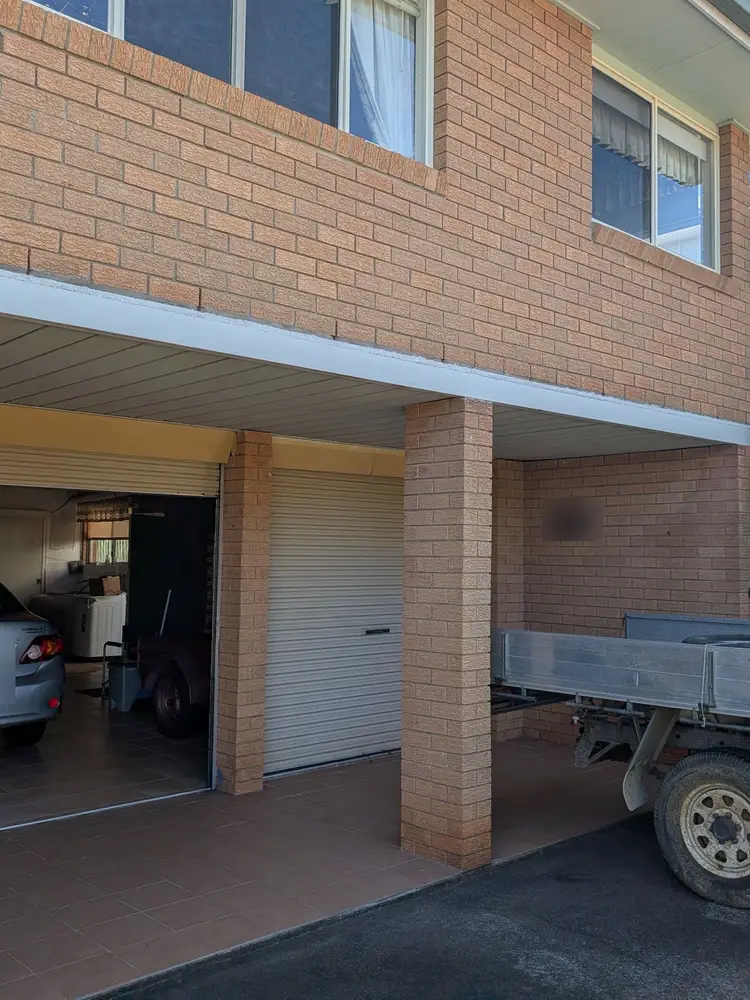 Carport beam above a garage, rust treated and repainted white